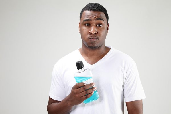 Man holding mouthwash bottle